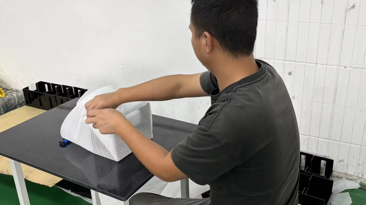 A Chengshuo team member wrapping a component in protective foam